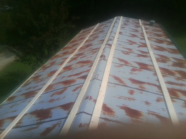 Rusted metal roof panels with new wood purlins before replacement — Storm Damage Roof Repair in Cotuit by Roofing Brothers