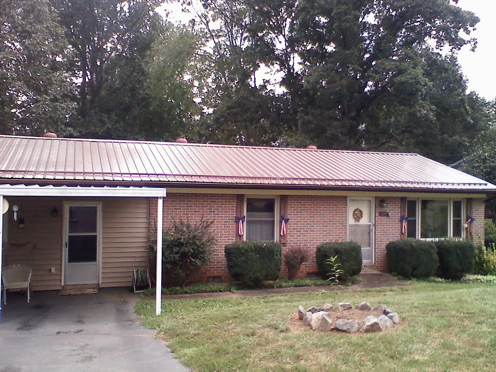 Bronze metal roof and carport on a brick ranch home — Roof Repair work by our crew in Cotuit